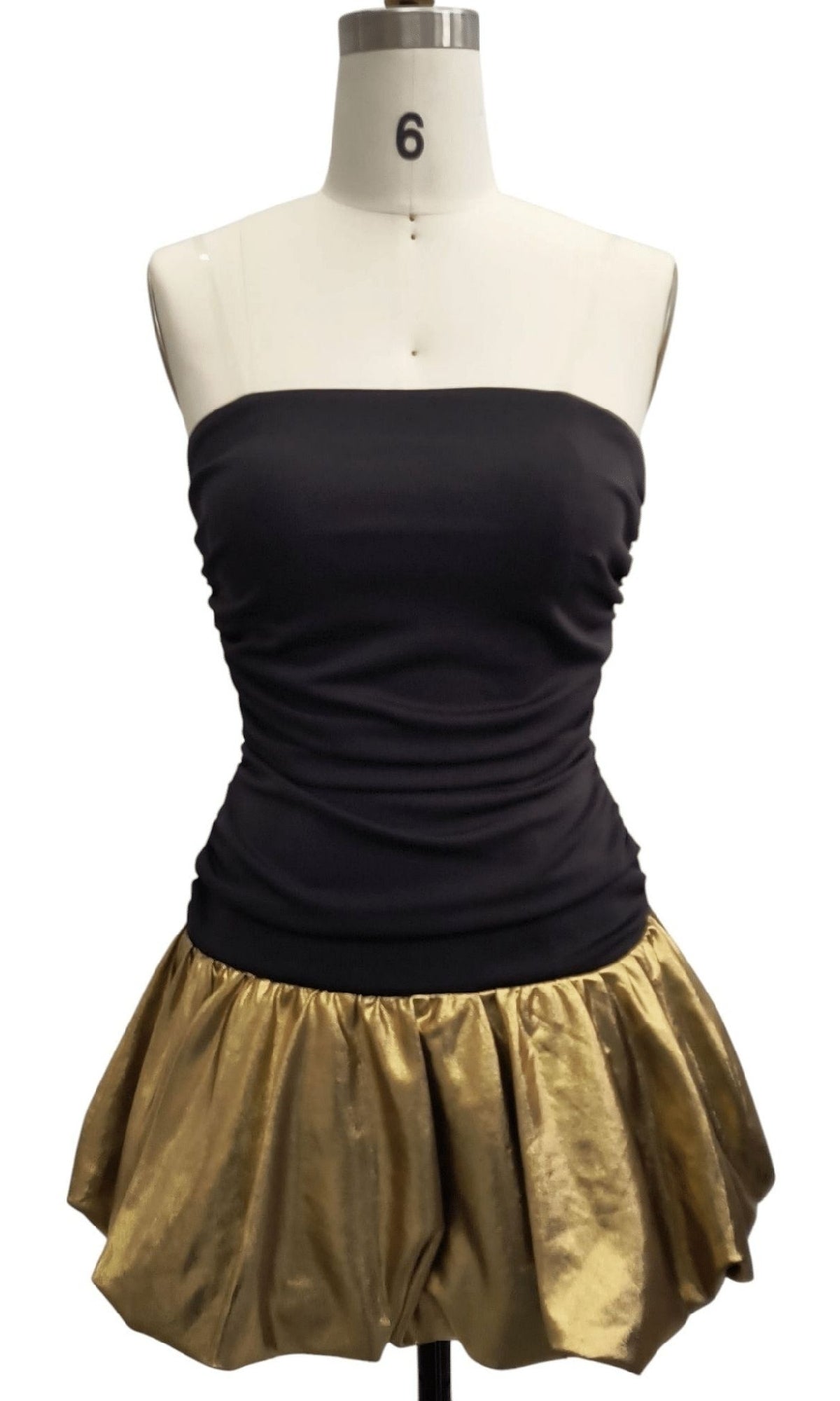 The Strapless Short Hoco Dress: 12483 is shown on a dress form, featuring a sleek strapless black top and a shiny gold bubble mini skirt perfect for parties or homecoming.